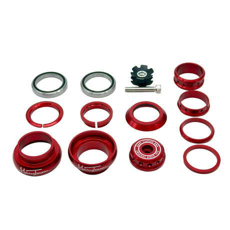 An 11-piece set of red anodized metal bicycle headset components, including cones, rings, seals, and a black spacer, arranged neatly on a white background.