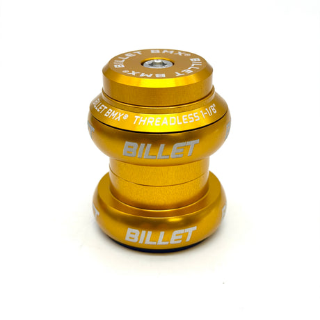 A gold anodized metal bicycle headset from Billet BMX, featuring white printed branding and text, shown on a clean white background.